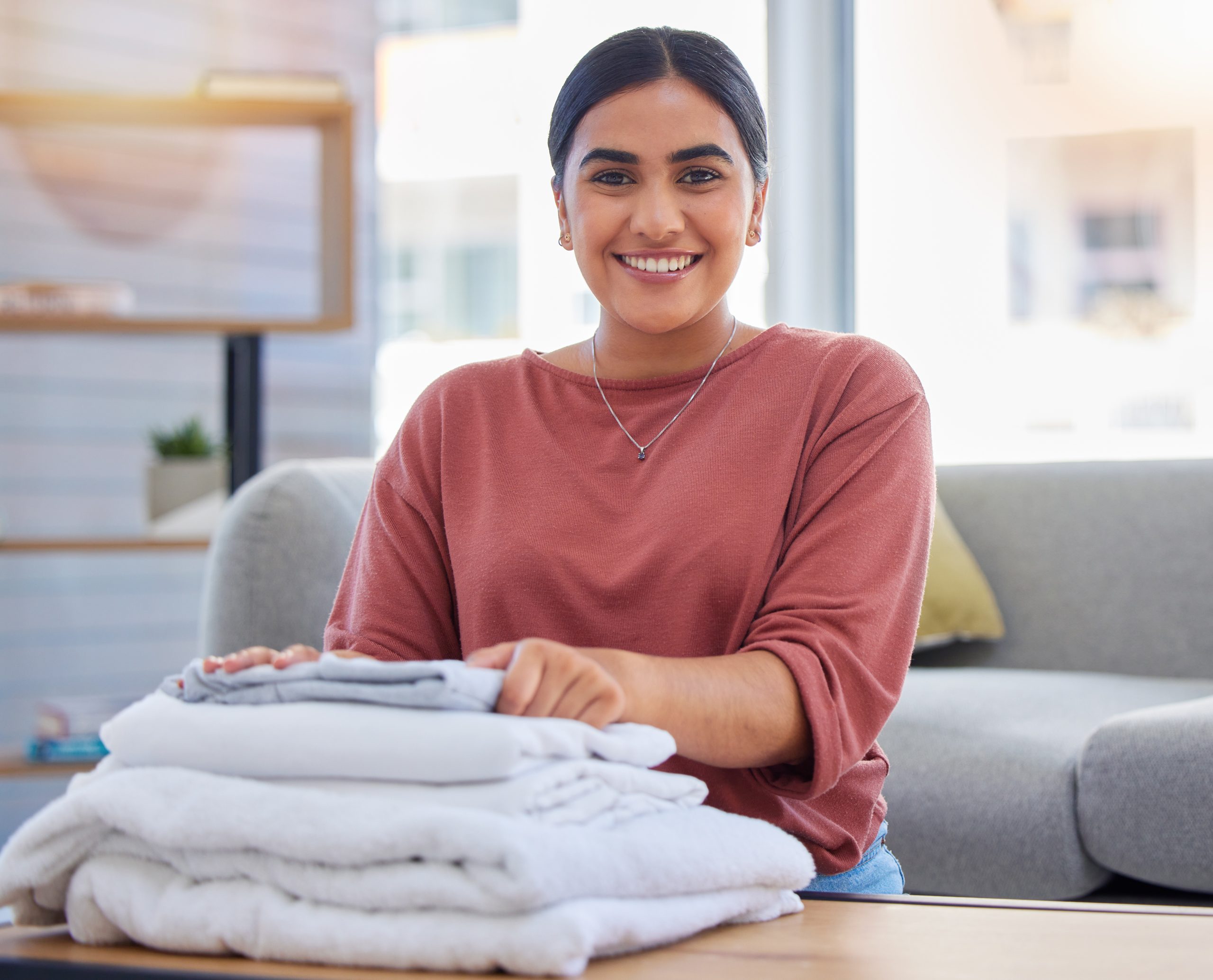 Cleaning, happy and laundry with portrait of woman in living room for housekeeping service, clothes.